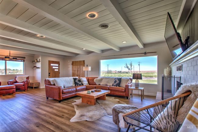 Living room featuring plenty of natural light, wood finished floors, beam ceiling, and a fireplace | Image 6