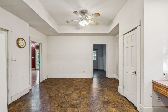Spare room featuring a ceiling fan, baseboards, stone finish floors, and a tray ceiling | Image 22