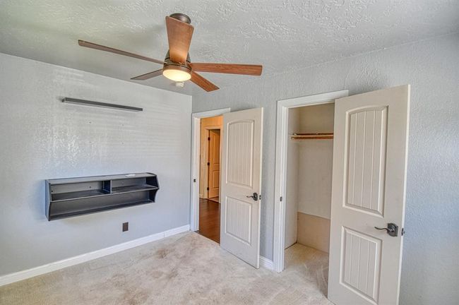 Unfurnished bedroom with carpet, baseboards, a ceiling fan, and a closet | Image 20