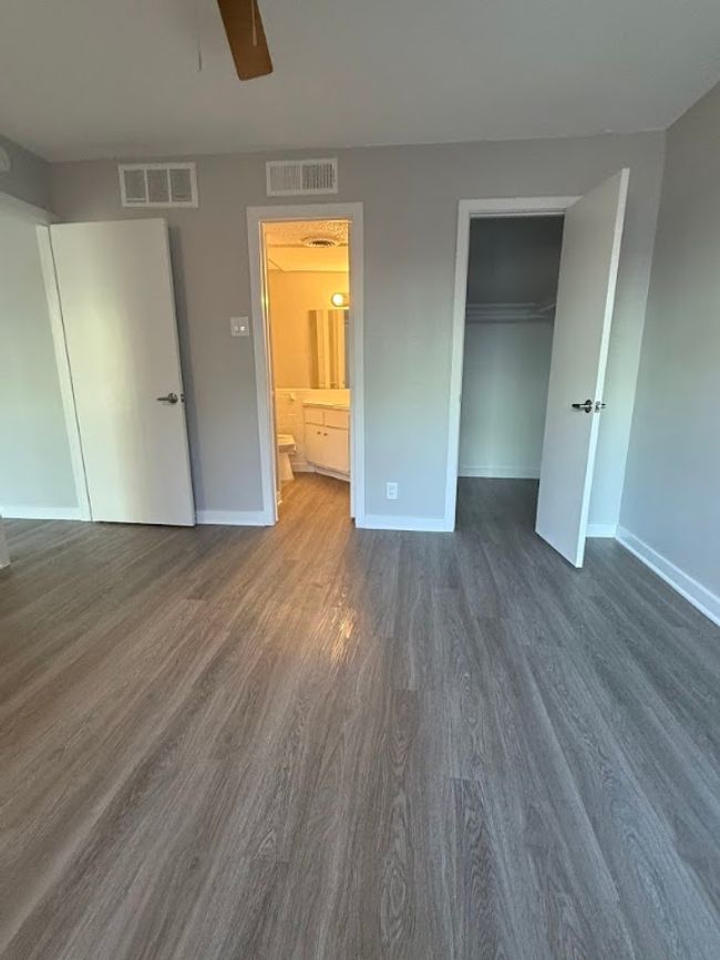 Unfurnished bedroom with dark wood finished floors, baseboards, a closet, and ensuite bathroom | Image 20