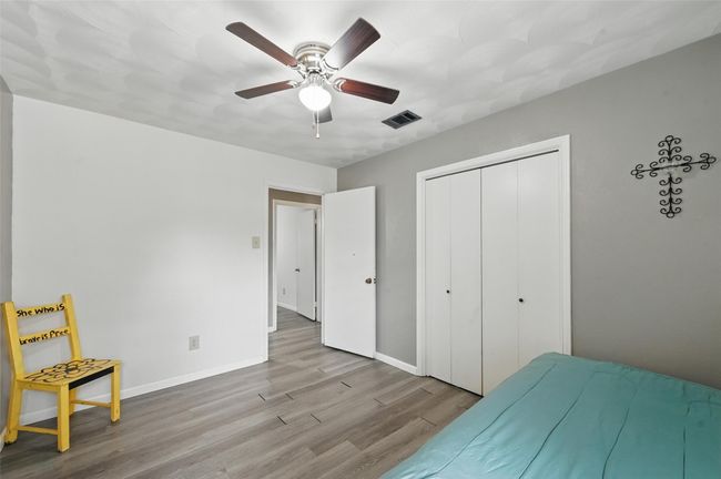 Bedroom with wood finished floors, baseboards, a closet, and a ceiling fan | Image 18