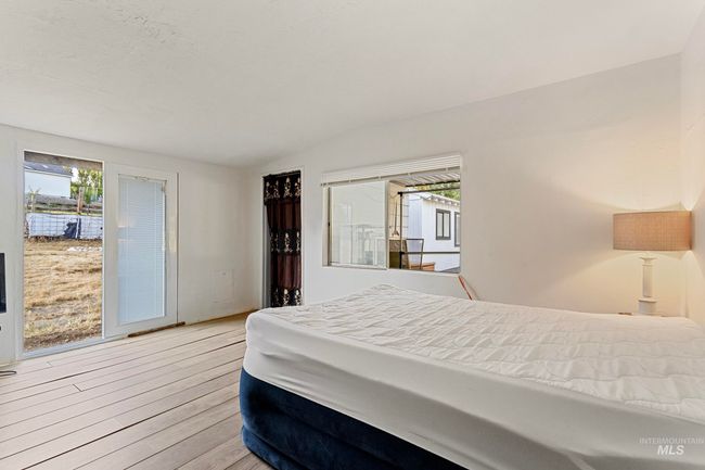 Bedroom with lofted ceiling and wood finished floors | Image 17