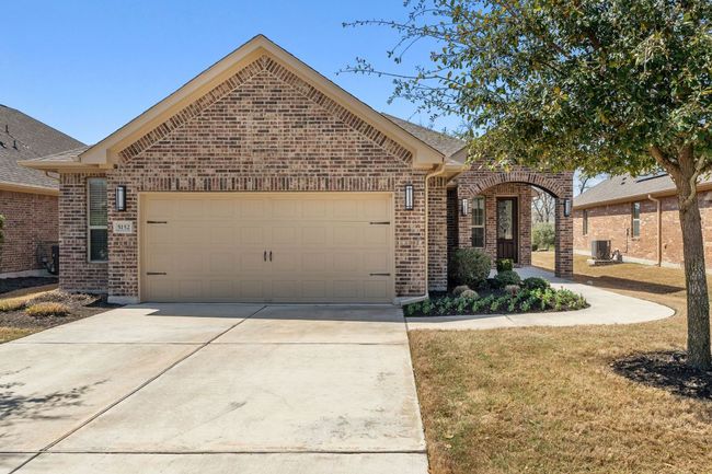 View of front of property with concrete driveway, an attached garage, brick siding, and roof with shingles | Image 4