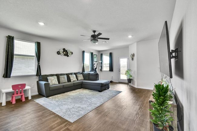 Living room featuring wood finished floors, a textured ceiling, a ceiling fan, baseboards, and recessed lighting | Image 11