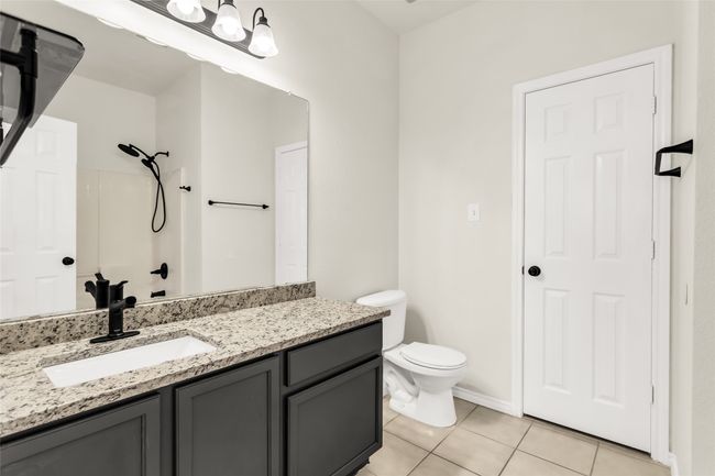 Full bathroom with tile patterned floors, vanity, and a shower | Image 12