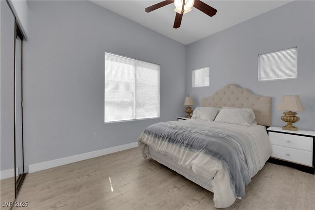 Bedroom with light wood-type flooring and a ceiling fan | Image 25