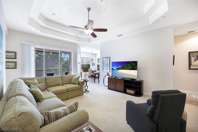Living room featuring a tray ceiling, carpet floors, and ceiling fan | Image 8