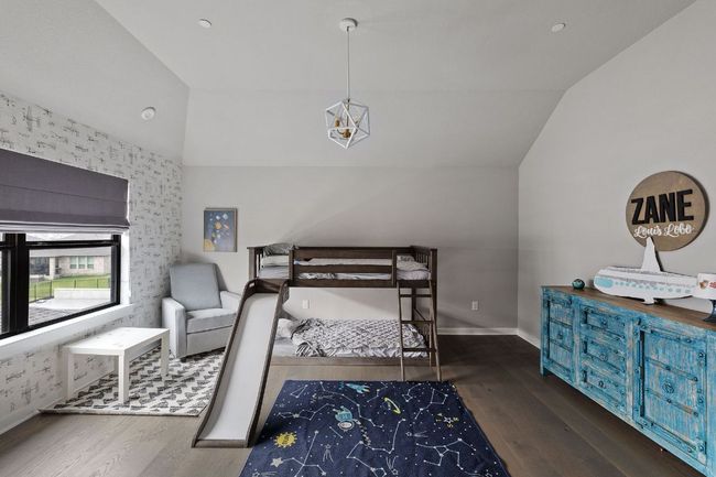 Bedroom with wood finished floors, baseboards, and lofted ceiling | Image 35