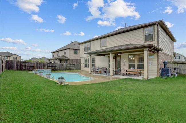The covered patio is perfect for grilling and relaxing, and the yard is spacious. | Image 22