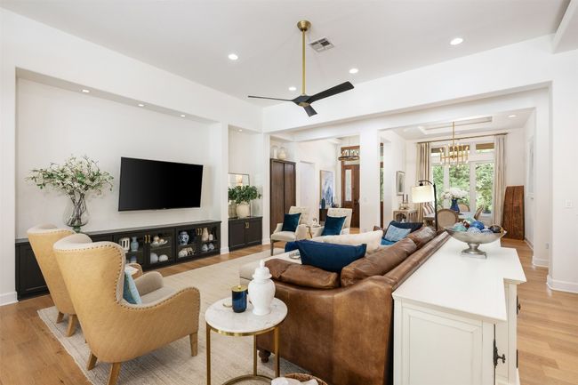 Living room featuring light wood finished floors, recessed lighting, a ceiling fan, a chandelier, and open concept living. | Image 6