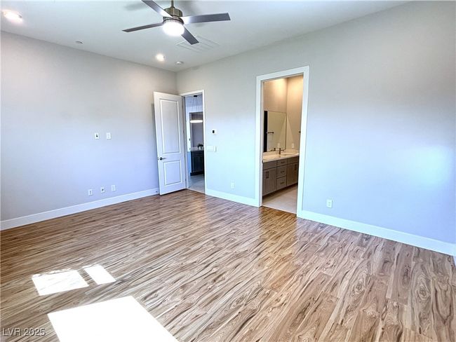 Unfurnished bedroom featuring visible vents, ensuite bathroom, baseboards, recessed lighting, and light wood finished floors | Image 23