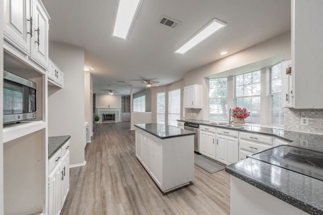 Kitchen with island open to breakfast area and family room. | Image 15