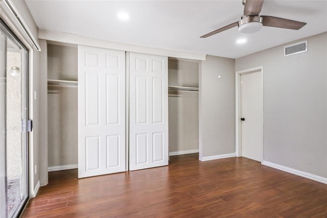 Unfurnished bedroom featuring wood finished floors, a closet, baseboards, and a ceiling fan | Image 9