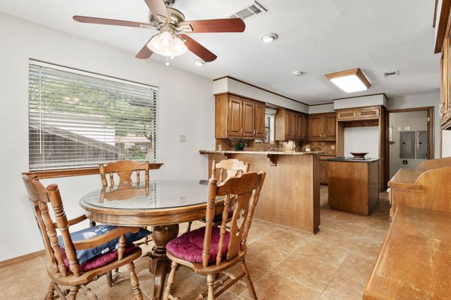 Dining space featuring light tile patterned floors, visible vents, and a ceiling fan | Image 16
