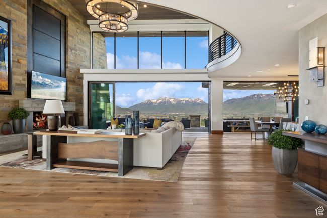 Living area featuring a chandelier, a mountain view, hardwood / wood-style flooring, and a towering ceiling | Image 6
