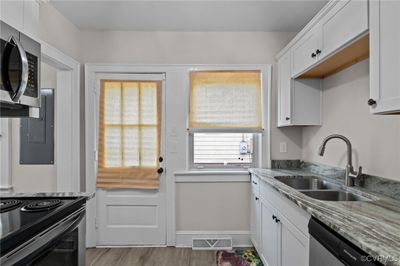 Kitchen featuring a wealth of natural light, white cabinetry, and appliances with stainless steel finishes | Image 3