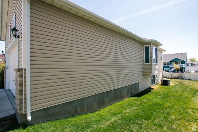 View of Eastside of property with a lawn and central AC unit | Image 34