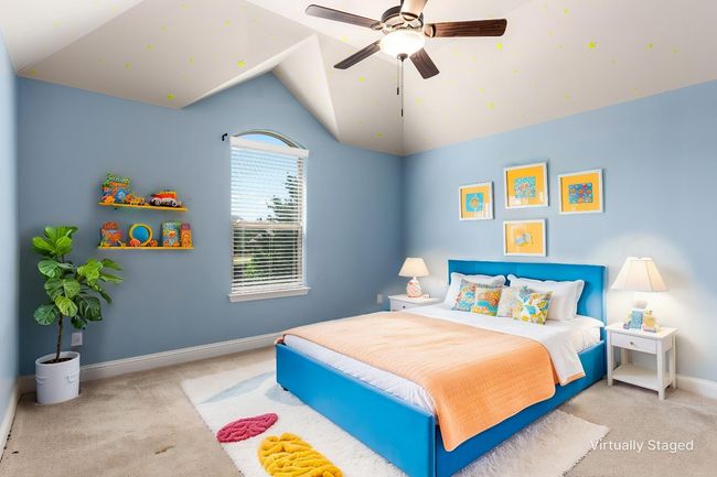 Carpeted bedroom with lofted ceiling, baseboards, and ceiling fan | Image 10
