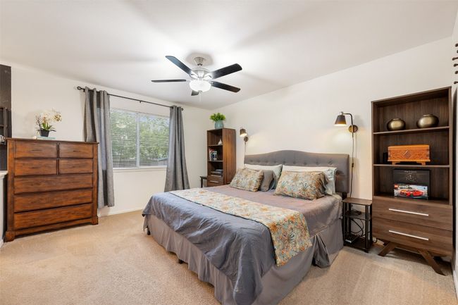 Bedroom with light colored carpet, ceiling fan, and baseboards | Image 17