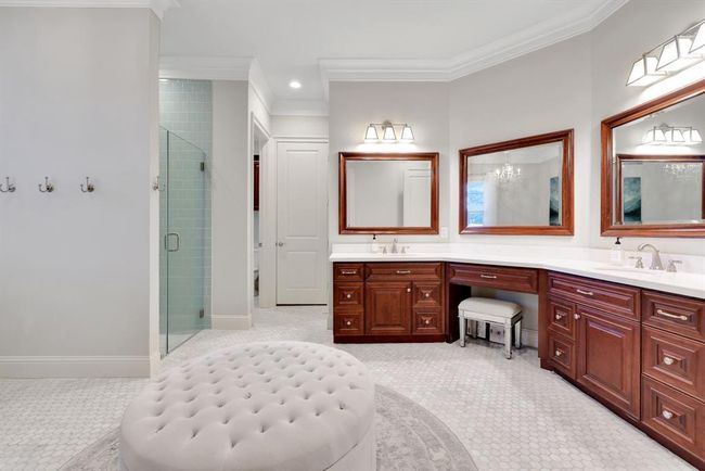 The spa-like primary ensuite bath is a luxurious retreat designed with both style and function in mind. Featuring elegant white octagon tile flooring, this serene space offers a dual vanity with quartz countertops, undermount sinks, and sleek brushed chrome plumbing and lighting fixtures. | Image 24