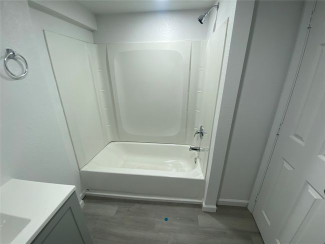 Bathroom with shower / washtub combination, wood finished floors, baseboards, and vanity | Image 11