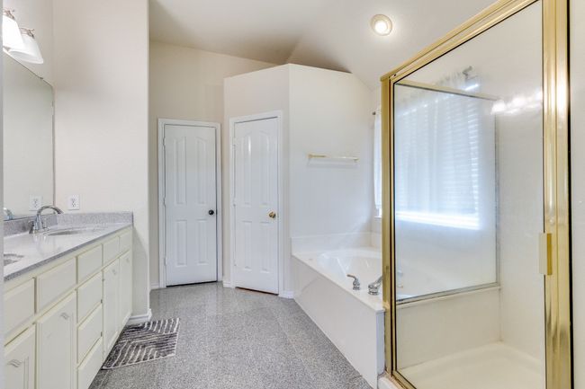 Bathroom featuring a stall shower, baseboards, vanity, and a bath | Image 18