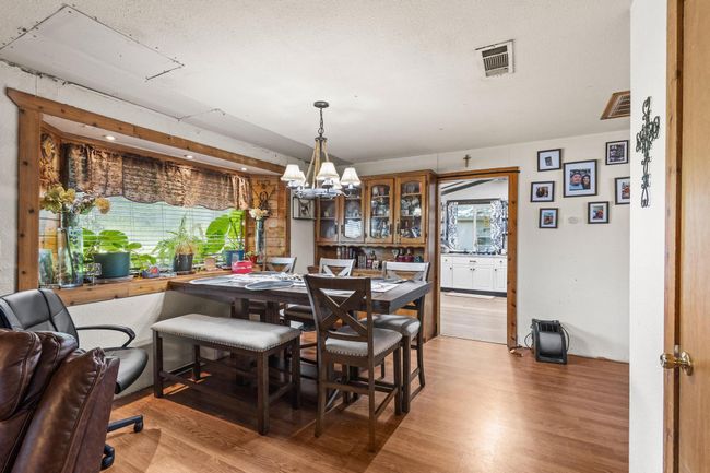 Dining area with a chandelier and light wood-style floors | Image 7