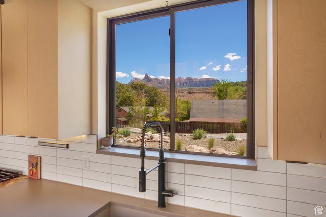 Kitchen view of decorative backsplash, a mountain view, and a sink | Image 8
