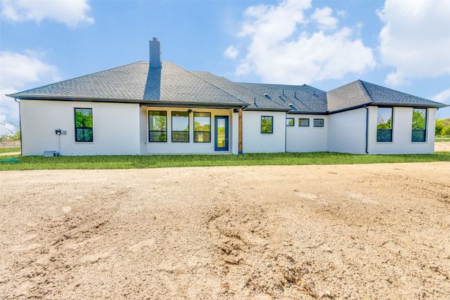 Back of property with brick siding, roof with shingles, and a chimney | Image 23