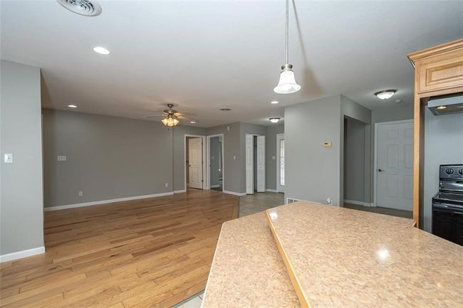 Kitchen featuring light wood-style flooring, baseboards, visible vents, and ceiling fan | Image 15