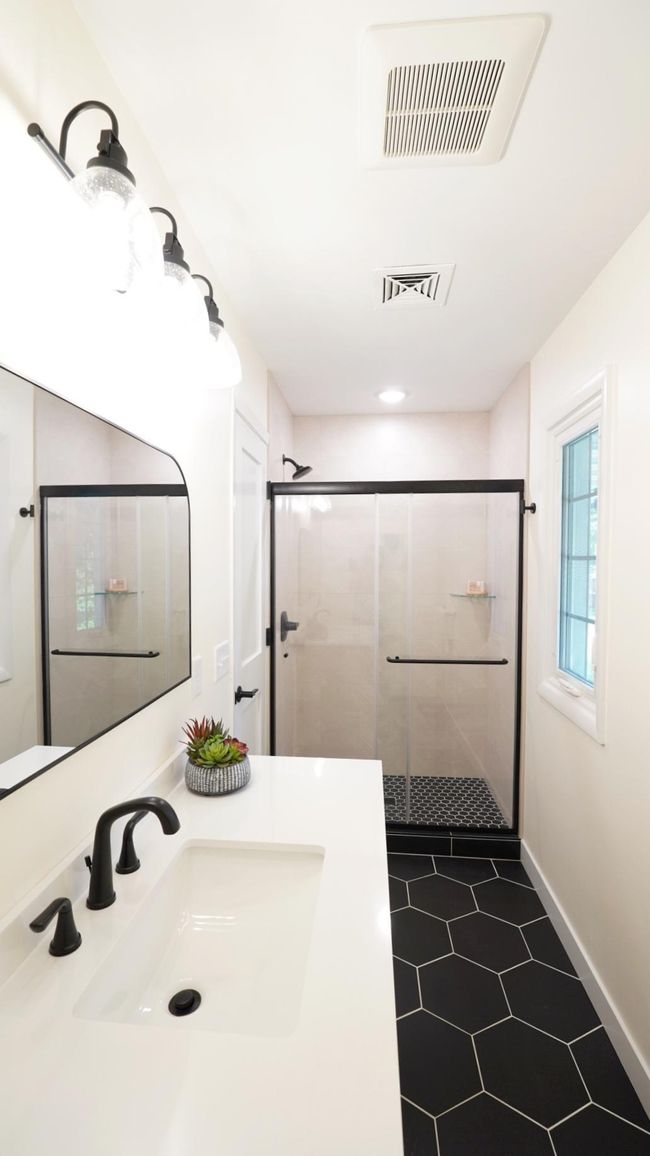The upstairs hall bath is newly remodeled and spotlights an eye-catching geometric shower tile, a new wood vanity with a large quartz countertop and brand new lighting. | Image 10