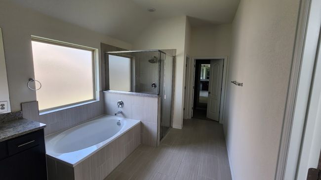 Bathroom featuring a shower stall, a bath, and lofted ceiling | Image 22