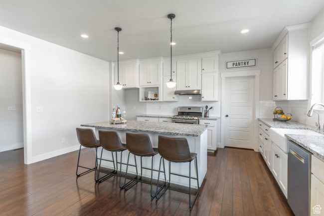 Granite counter tops, gas range, and farmhouse sink. | Image 19
