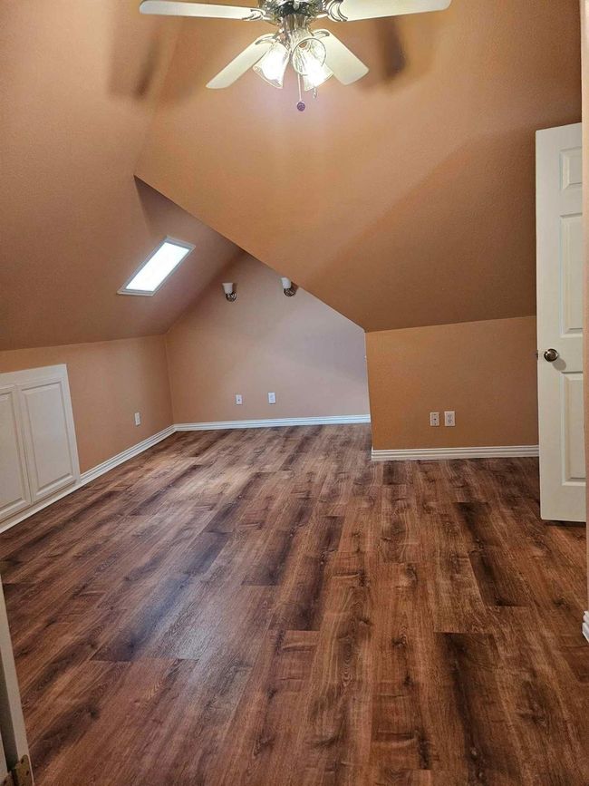 Bonus room with a ceiling fan, lofted ceiling, and dark wood-style flooring | Image 7