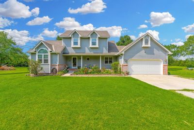 View of front facade with a garage and a front lawn | Image 1