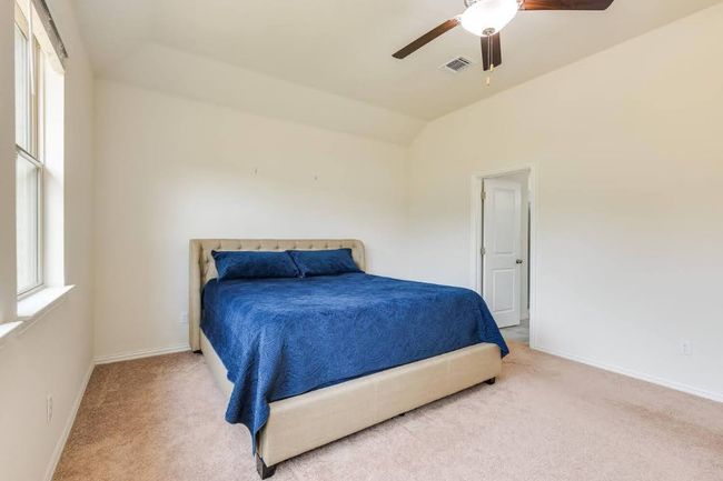 Bedroom with carpet floors, baseboards, lofted ceiling, and ceiling fan | Image 21