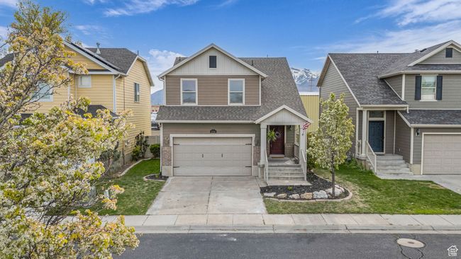 Traditional home with an attached garage, a front lawn, roof with shingles, and driveway | Image 24