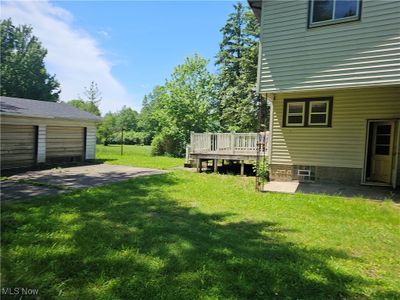 View of yard featuring a wooden deck and a patio area | Image 1