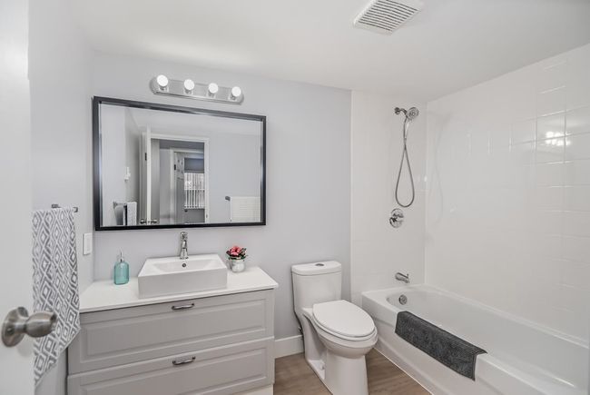 Full bath with toilet, wood finished floors, vanity, and shower / washtub combination | Image 12