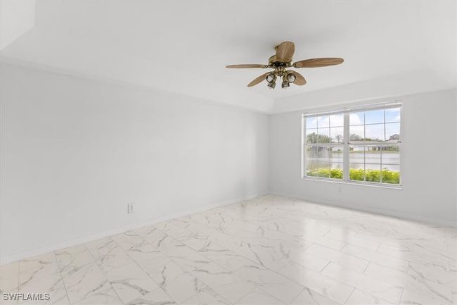 Tiled empty room featuring a water view and ceiling fan | Image 7