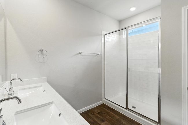 Bathroom featuring a shower stall, wood finished floors, and double vanity | Image 13