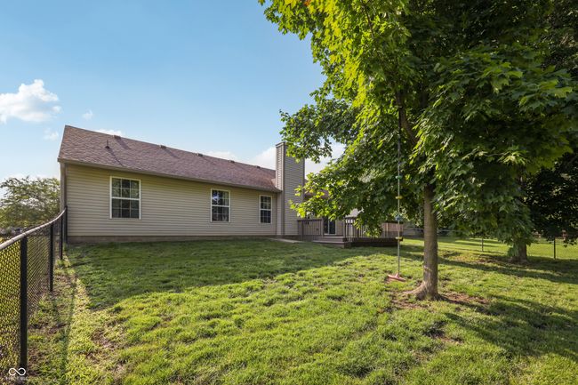 rear view of house featuring a fenced backyard, a wooden deck, and a chimney | Image 32