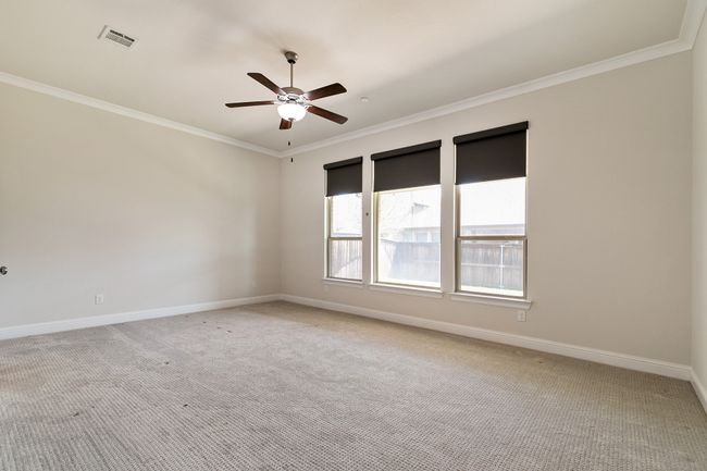 Empty room featuring baseboards, light colored carpet, ceiling fan, and ornamental molding | Image 16