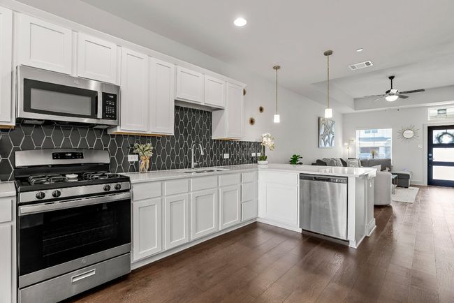 The kitchen is a showstopper, featuring sleek white granite countertops, stainless steel appliances and plenty of storage. | Image 9