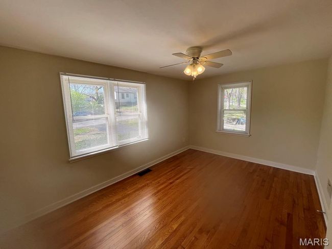Empty room with visible vents, wood finished floors, and baseboards | Image 21