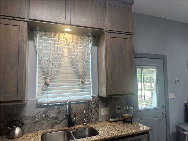 Kitchen featuring a sink, tasteful backsplash, light stone counters, and dishwasher | Image 33