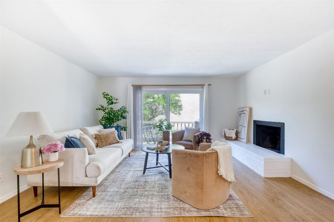 Living area with wood finished floors and a brick fireplace | Image 6