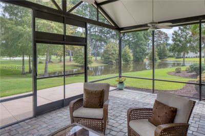 Sunroom / solarium with plenty of natural light, a water view, and ceiling fan | Image 2