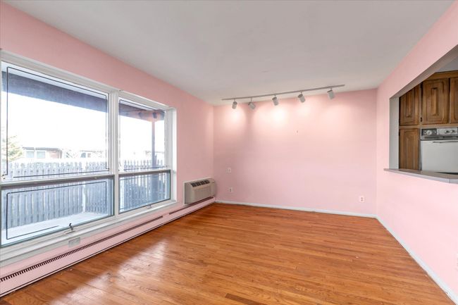 Featuring a baseboard heating unit, a wall mounted air conditioner, light wood-style flooring, and baseboards | Image 8
