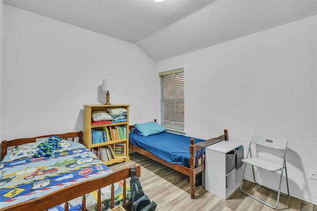 Bedroom with wood finished floors and lofted ceiling | Image 23